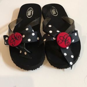 Black flip flops with polka dotted bow and red A
